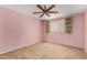 Bedroom with a ceiling fan, window, carpet, and pink painted walls at 4062 W Mescal St, Phoenix, AZ 85029