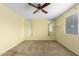 Bright bedroom featuring neutral colored walls, a ceiling fan, standard-sized windows, and mirrors at 4062 W Mescal St, Phoenix, AZ 85029