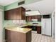 Functional kitchen area with wooden cabinets, countertops, standard appliances, and a window at 4062 W Mescal St, Phoenix, AZ 85029