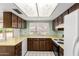 Functional kitchen area with wooden cabinets, countertops, standard appliances, and tile floor at 4062 W Mescal St, Phoenix, AZ 85029