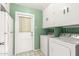 A bright laundry room features a washer, dryer, and ample storage space at 4062 W Mescal St, Phoenix, AZ 85029
