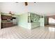 Open living room showcasing the kitchen area, shelving, cabinets, and spacious tiled floors at 4062 W Mescal St, Phoenix, AZ 85029