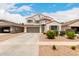 Two-story stucco home featuring a tile roof, shuttered windows, an attached garage, and desert landscaping at 4142 E Sandy Way, Gilbert, AZ 85297