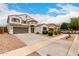 View of the two-story home featuring a tile roof, desert landscaping, an attached garage, and a private entry balcony at 4142 E Sandy Way, Gilbert, AZ 85297