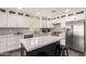 Modern kitchen with white cabinetry, stainless steel appliances, an island with seating, and sleek countertops, providing both style and functionality at 4142 E Sandy Way, Gilbert, AZ 85297