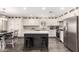 Well-lit kitchen with white cabinets, stainless steel appliances, an island with seating, and modern lighting, perfect for entertaining at 4142 E Sandy Way, Gilbert, AZ 85297