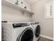 Laundry room with front load washer and dryer and a shelf for storage at 4142 E Sandy Way, Gilbert, AZ 85297