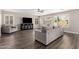 Living room features neutral walls, wood floors, large windows, comfortable seating, and entertainment center at 4142 E Sandy Way, Gilbert, AZ 85297