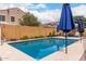 Inviting backyard pool with blue umbrellas and lush landscaping, perfect for relaxation at 4142 E Sandy Way, Gilbert, AZ 85297