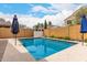 Beautiful backyard pool with blue umbrellas and landscaping, offering a perfect outdoor oasis at 4142 E Sandy Way, Gilbert, AZ 85297