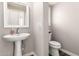 Clean powder room features pedestal sink, framed mirror, and modern toilet at 4142 E Sandy Way, Gilbert, AZ 85297