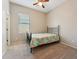 Cozy bedroom with a wrought iron bed frame, ceiling fan, and a window with blinds at 43884 W Kramer Ln, Maricopa, AZ 85138