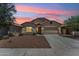 Inviting exterior of the home with a desert landscape and attached two car garage at 43884 W Kramer Ln, Maricopa, AZ 85138