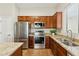 A view of the kitchen featuring stainless steel appliances, wood cabinets, and granite countertops at 43884 W Kramer Ln, Maricopa, AZ 85138