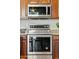 The modern stainless steel range oven and microwave are complemented by wooden cabinets and granite countertops at 43884 W Kramer Ln, Maricopa, AZ 85138
