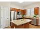 The kitchen features stainless steel appliances, wood cabinets, and a granite island at 43884 W Kramer Ln, Maricopa, AZ 85138