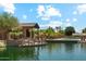 Community pond with a covered gazebo, seating, and lush landscaping at 43884 W Kramer Ln, Maricopa, AZ 85138