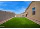 A spacious backyard featuring artificial turf, providing a low-maintenance outdoor space for relaxation and entertainment at 4424 W Vervain Ave, San Tan Valley, AZ 85144
