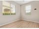 Bright bedroom featuring two windows and light wood floors at 4424 W Vervain Ave, San Tan Valley, AZ 85144