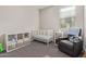Comfortable Bedroom featuring a crib, shelving unit, and gray rocking chair at 4424 W Vervain Ave, San Tan Valley, AZ 85144