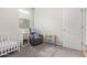 Cozy Bedroom featuring a gray rocking chair, crib, and door at 4424 W Vervain Ave, San Tan Valley, AZ 85144