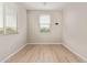 Bright bedroom featuring two windows, light wood floors, and white baseboards at 4424 W Vervain Ave, San Tan Valley, AZ 85144