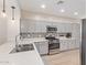 Updated kitchen with stainless steel appliances, gray cabinets, and quartz countertops at 4424 W Vervain Ave, San Tan Valley, AZ 85144