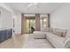 Bright living room with hardwood floors, neutral sectional sofa, and sliding doors to patio at 4424 W Vervain Ave, San Tan Valley, AZ 85144
