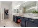 Well-lit bathroom featuring double sinks, vanity area, modern fixtures, and a large, framed mirror at 5330 W Thresher Way, Laveen, AZ 85339