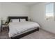 Cozy bedroom featuring a padded headboard, side table, lamps and large window for natural light at 5330 W Thresher Way, Laveen, AZ 85339