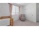 Tranquil Bedroom featuring a crib, glider chair and a window dressed in lovely pink drapes at 5330 W Thresher Way, Laveen, AZ 85339