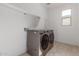 Clean laundry room featuring modern washer and dryer units, tile flooring and built-in shelving at 5330 W Thresher Way, Laveen, AZ 85339