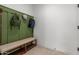 Practical mudroom with convenient bench, lower shelf, coat hooks, and stylish tile flooring at 5330 W Thresher Way, Laveen, AZ 85339
