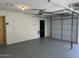 Well-lit garage with a newly painted floor, a black access door, a white garage door, and white brick walls at 5342 E Des Moines St, Mesa, AZ 85205