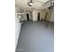Spacious garage interior featuring a freshly painted floor, white brick walls, shelving, and ample open space at 5342 E Des Moines St, Mesa, AZ 85205