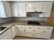 Well-lit kitchen with white cabinetry, granite countertops, and stainless steel appliances at 5342 E Des Moines St, Mesa, AZ 85205