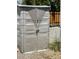 Close-up of outdoor gray plastic storage cabinet with double doors, locked near a wood fence with rock ground cover at 5342 E Des Moines St, Mesa, AZ 85205