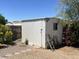 Outdoor storage shed with aluminum siding, a window, and a weathered ladder, accented with plants and gravel at 5342 E Des Moines St, Mesa, AZ 85205