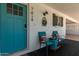 Quaint front porch featuring a bright blue door, decorative shutters, cozy seating, and charming details for a welcoming ambiance at 701 N 55Th Pl, Mesa, AZ 85205