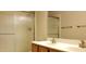 Bathroom with double sinks, wood cabinet, mirrored vanity, and walk-in shower at 7825 W Crocus Dr, Peoria, AZ 85381