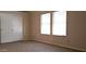 Bright bedroom featuring carpeted floor, closet, and natural light from windows at 7825 W Crocus Dr, Peoria, AZ 85381