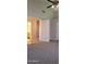 View of a bedroom with carpet, ceiling fan, and view to bath and closet area at 7825 W Crocus Dr, Peoria, AZ 85381