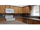 Kitchen with wooden cabinets, white appliances, and neutral countertops at 7825 W Crocus Dr, Peoria, AZ 85381