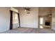 Open living room features a ceiling fan and windows, connecting to an adjacent room with a fireplace at 7825 W Crocus Dr, Peoria, AZ 85381