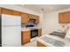 Efficient kitchen features light wood cabinets, a white refrigerator, and modern appliances at 8140 N 107Th Ave # 287, Peoria, AZ 85345