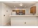 Efficient kitchen features light wood cabinets, a breakfast bar, white appliances, and a colorful backsplash at 8140 N 107Th Ave # 287, Peoria, AZ 85345