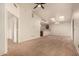 Bright, open-concept living room features neutral carpet, vaulted ceilings, fan, and a view into the kitchen at 8140 N 107Th Ave # 287, Peoria, AZ 85345