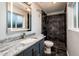 A modern bathroom featuring a granite countertop, LED mirror, and tiled walk-in shower at 8408 E Rancho Vista Dr, Scottsdale, AZ 85251
