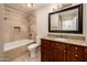 Beautiful bathroom showcasing granite countertop, dark wood vanity, tub, shower and tiled walls at 8408 E Rancho Vista Dr, Scottsdale, AZ 85251