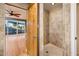 A tiled walk-in shower is pictured adjacent to a bright room with backyard views at 8408 E Rancho Vista Dr, Scottsdale, AZ 85251
